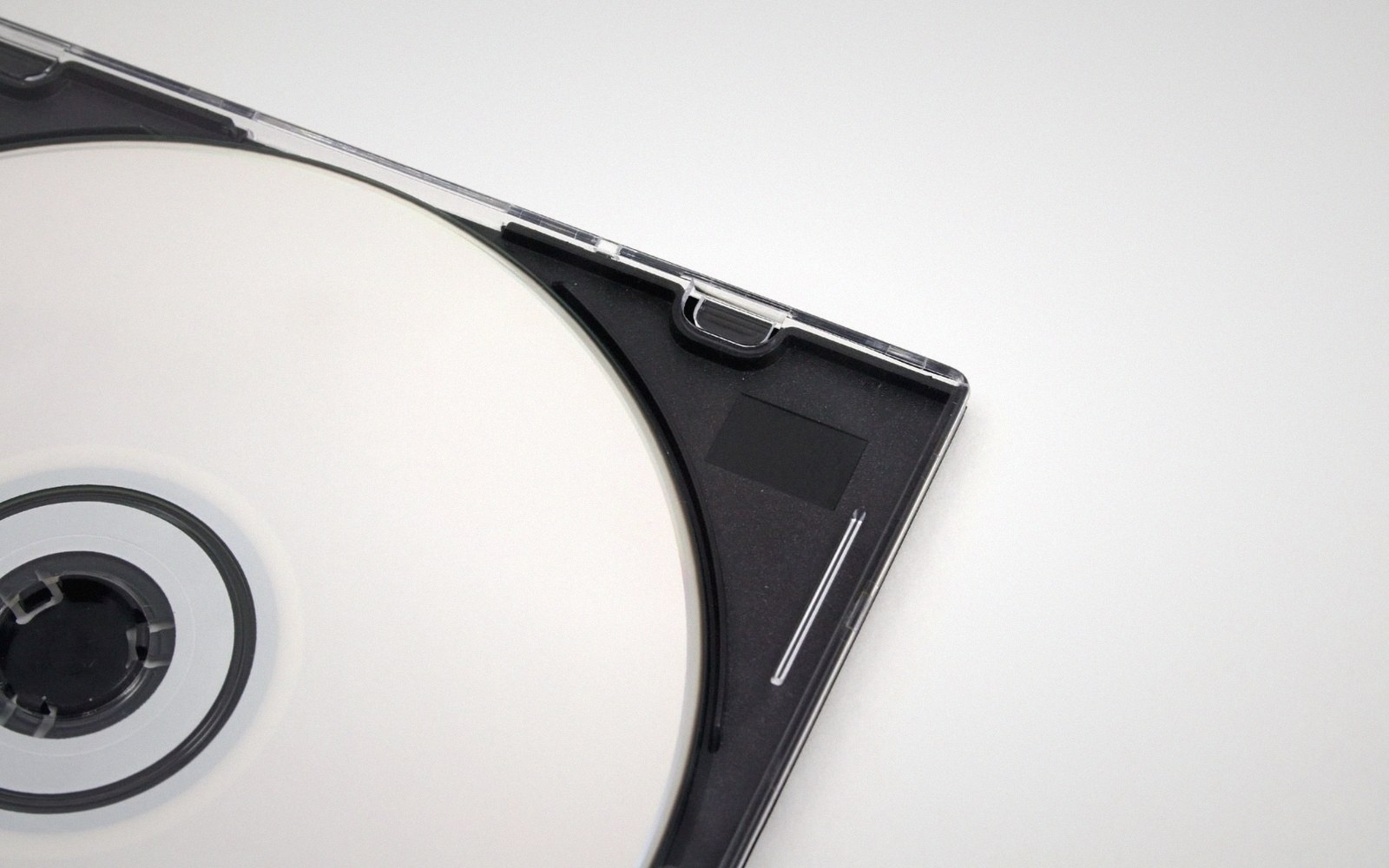 Close-up of a blank white cd resting inside its open plastic jewel case