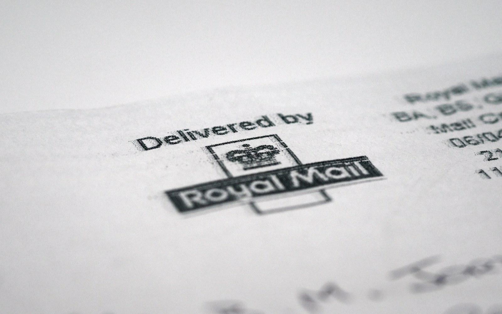 Close-up of a "Delivered by Royal Mail" stamp printed on an envelope