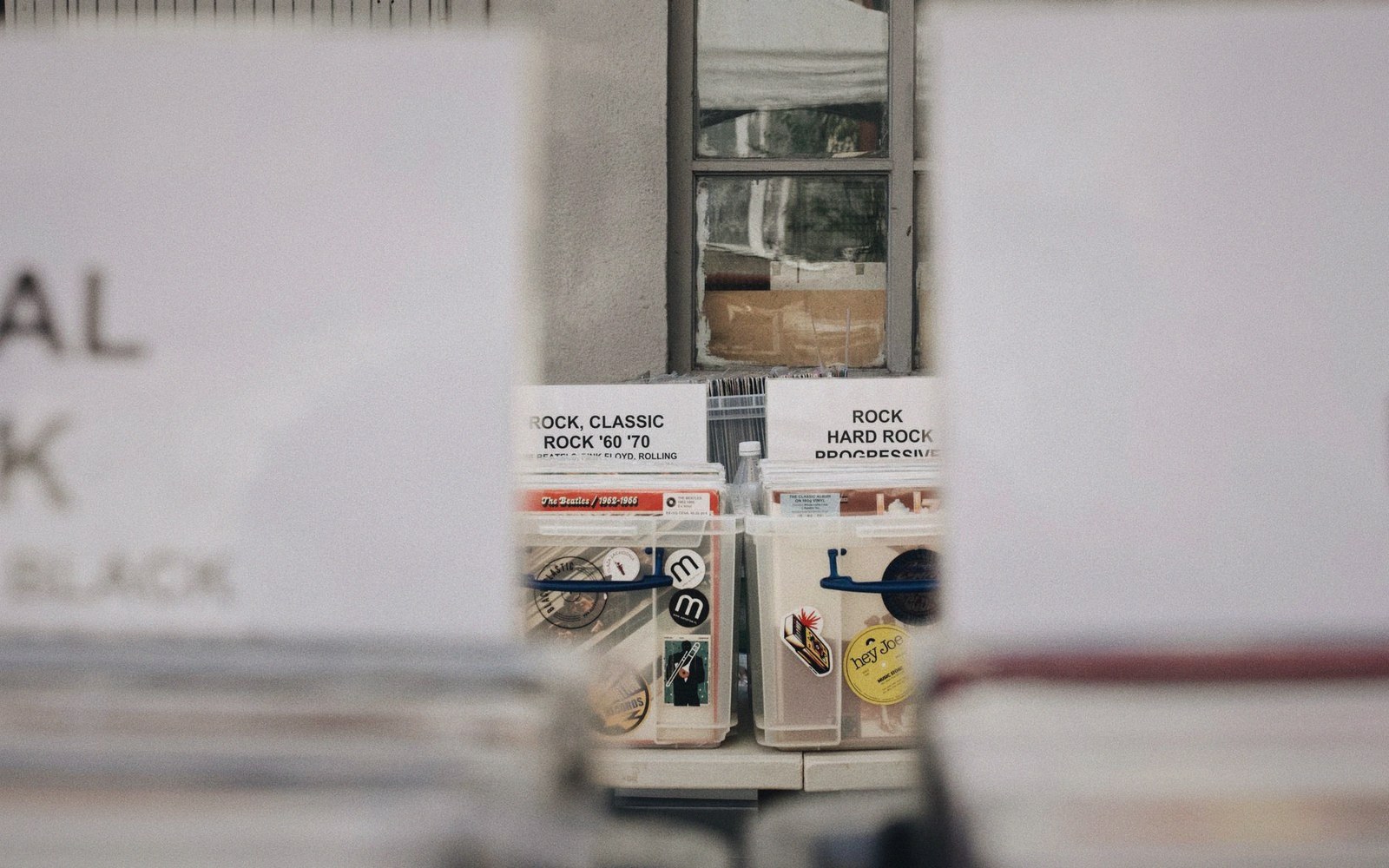 Vinyl record crates labeled "rock, classic rock" and "rock, hard rock" in a shop