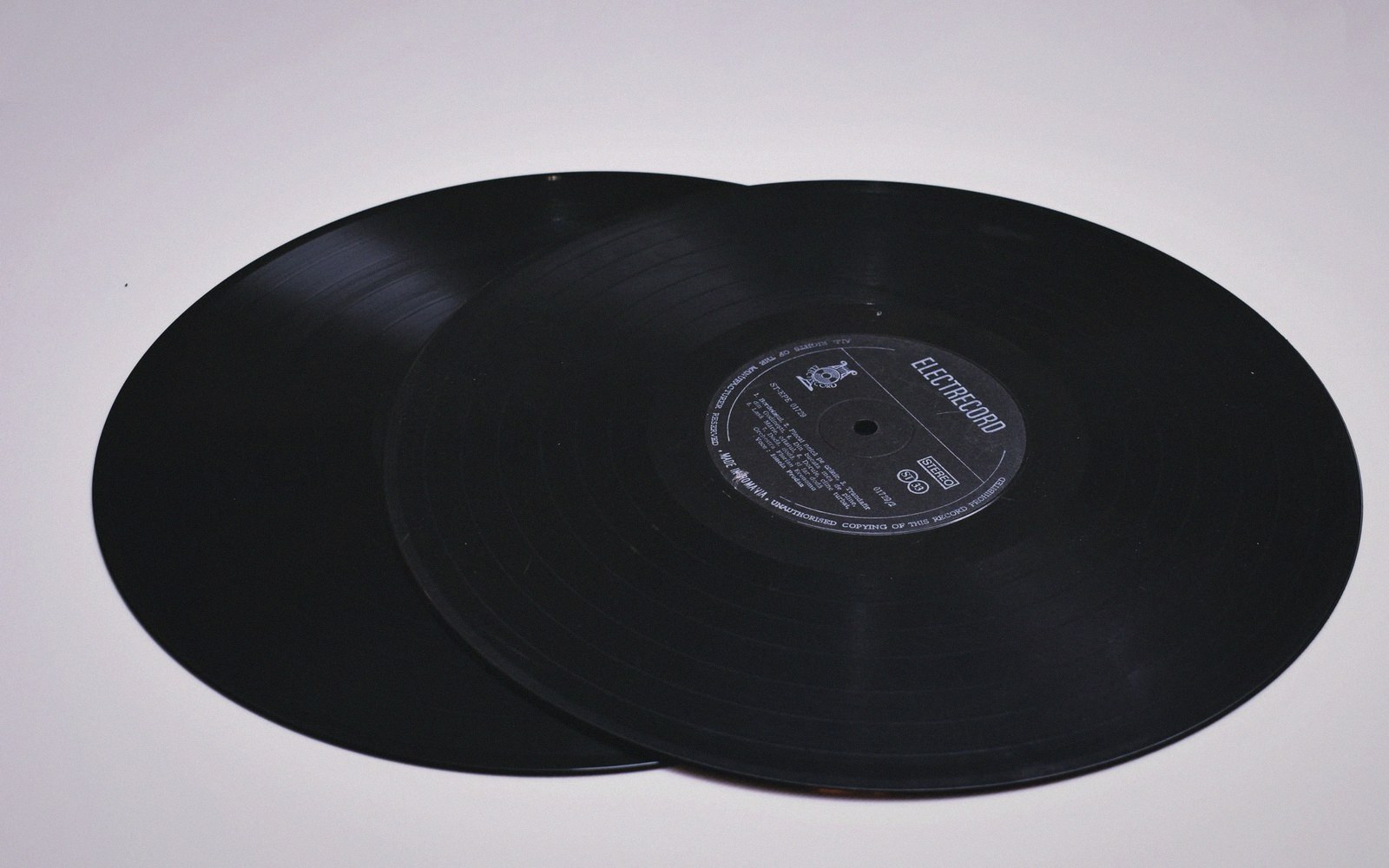 Two black vinyl LPs overlapping on a plain surface, showing an Electrecord label